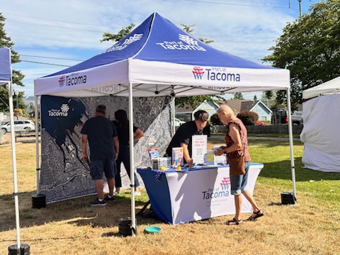 Someone stopping by a booth to take something from the table.